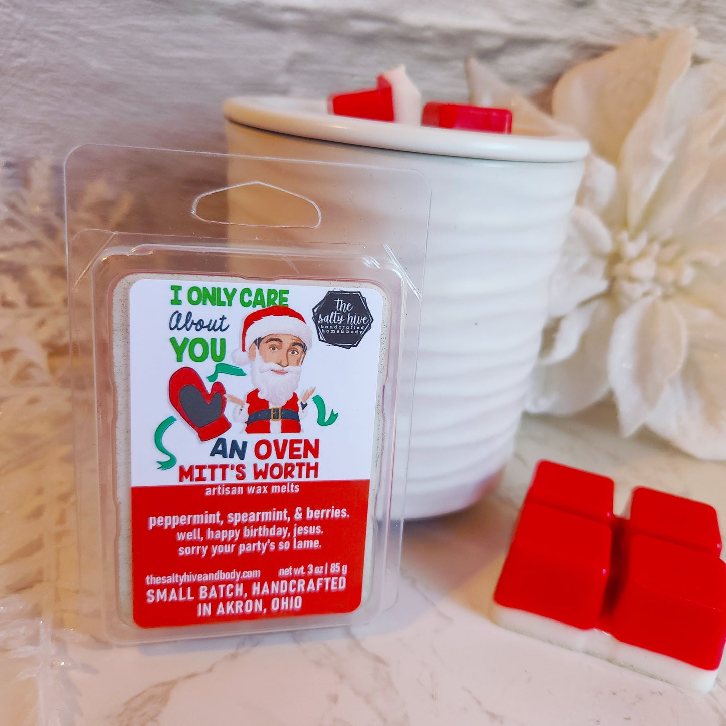 Wax melt package with Santa Claus design on a white surface with red wax melts. michael scott as santa from the office