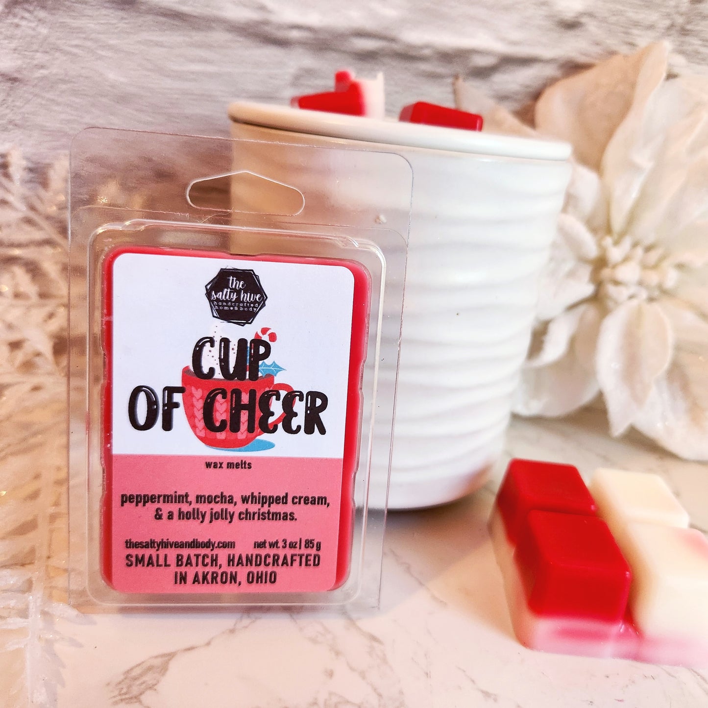 Wax melt package labeled 'Cup of Cheer' with a mug design on a wooden surface.