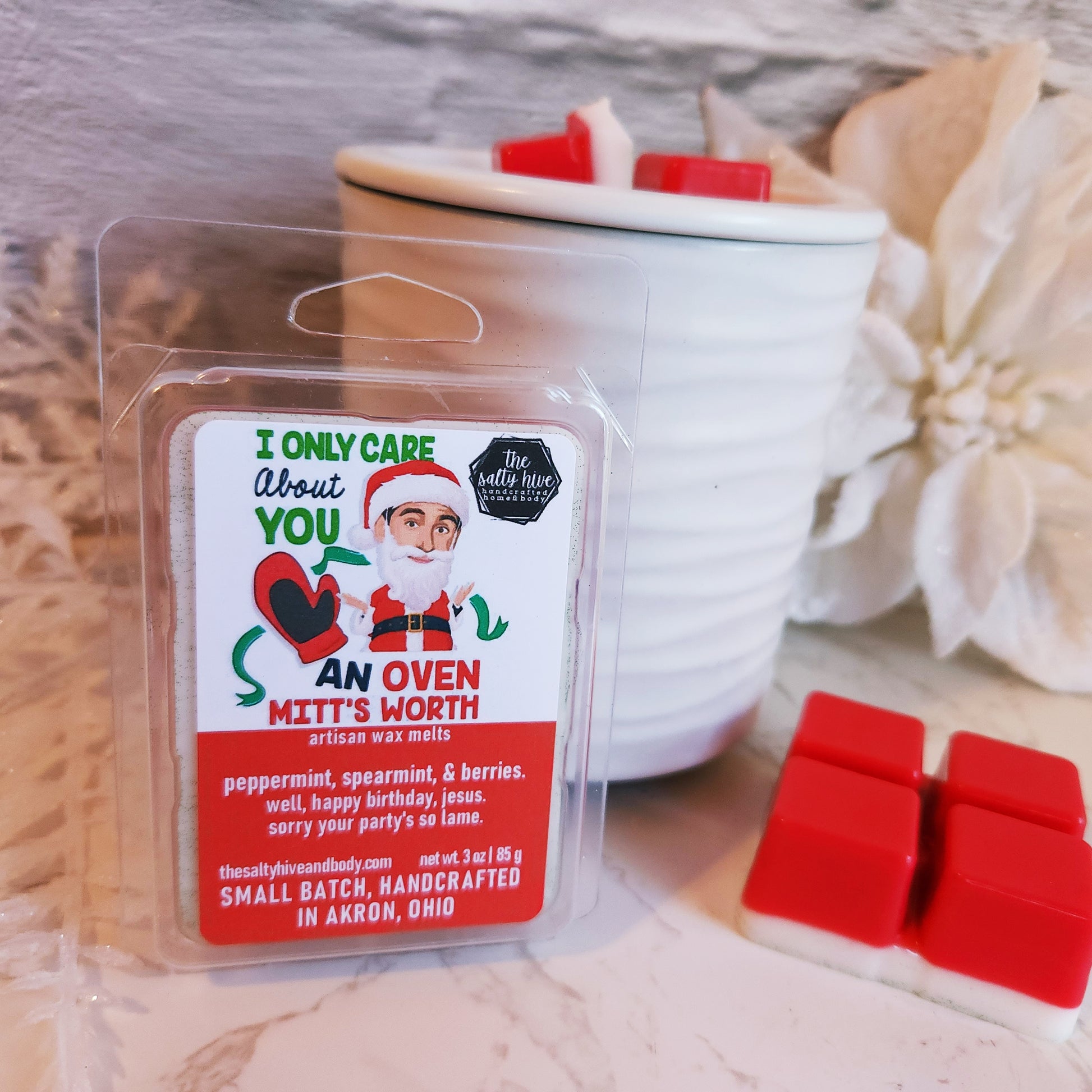 Wax melt package with Santa Claus design on a white surface with red wax melts. michael scott as santa from the office