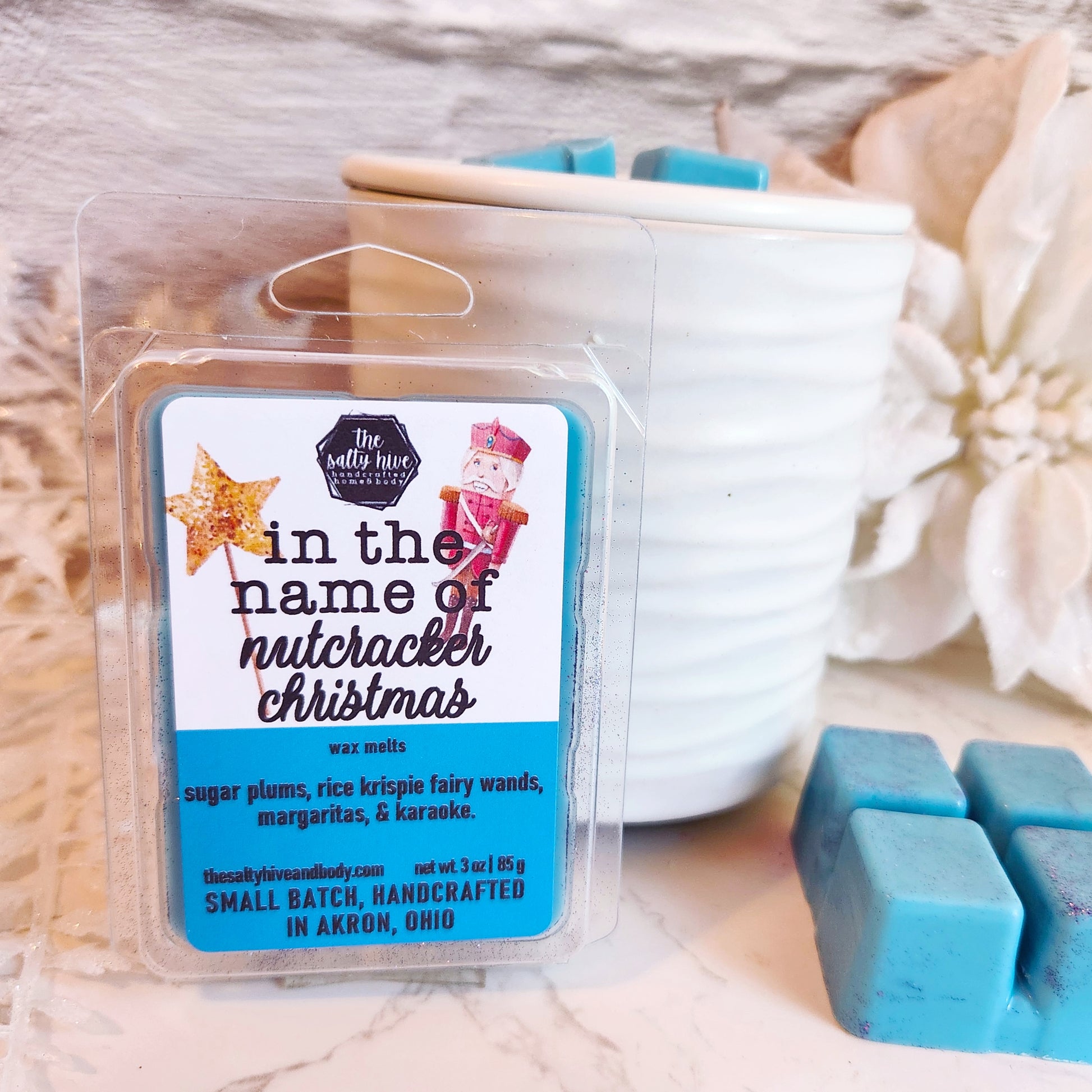 Wax melts packaging with 'In the name of Nutcracker Christmas' label on a wooden surface. the office tv show christmas